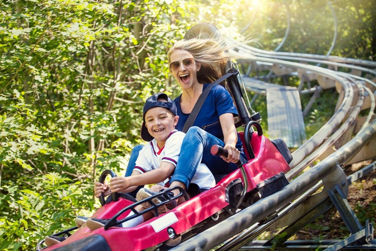 Mother and son on a mountain coaster in the mountains.