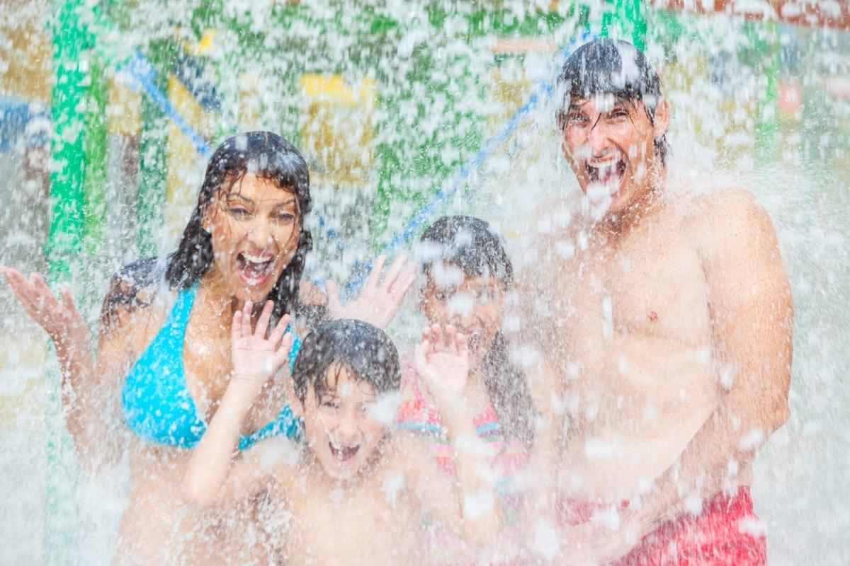 mom, dad, daughter, and son at waterpark having fun in the water together